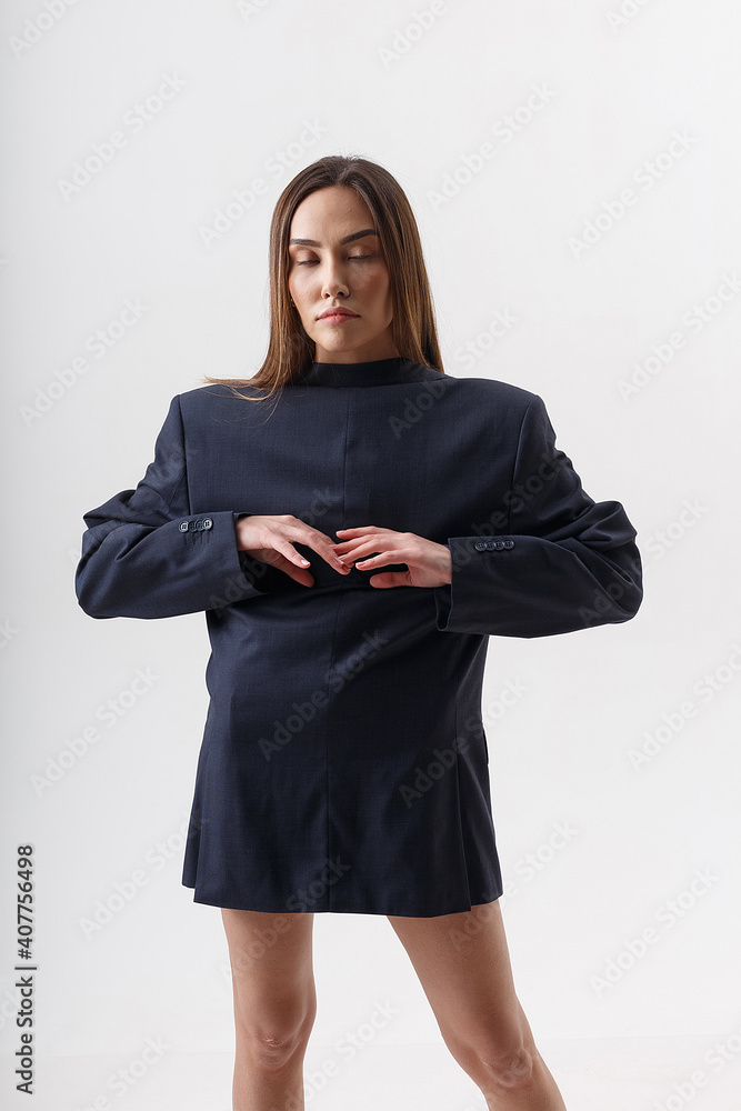 Fototapeta premium portrait of young attractive asian woman with long hair wearing blue suit on the contrary, isolated on white studio background. skinny pretty female posing on cyclorama. model tests of beautiful lady