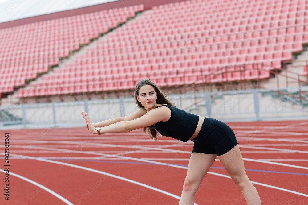 Young, beautiful girl athlete in sportswear is training at the stadium Young, beautiful girl athlete in sportswear is training at the stadium