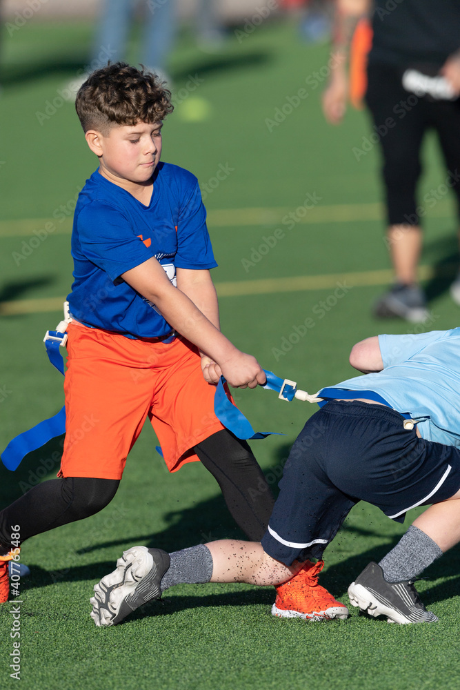 Fototapeta premium Young boy playing flag football