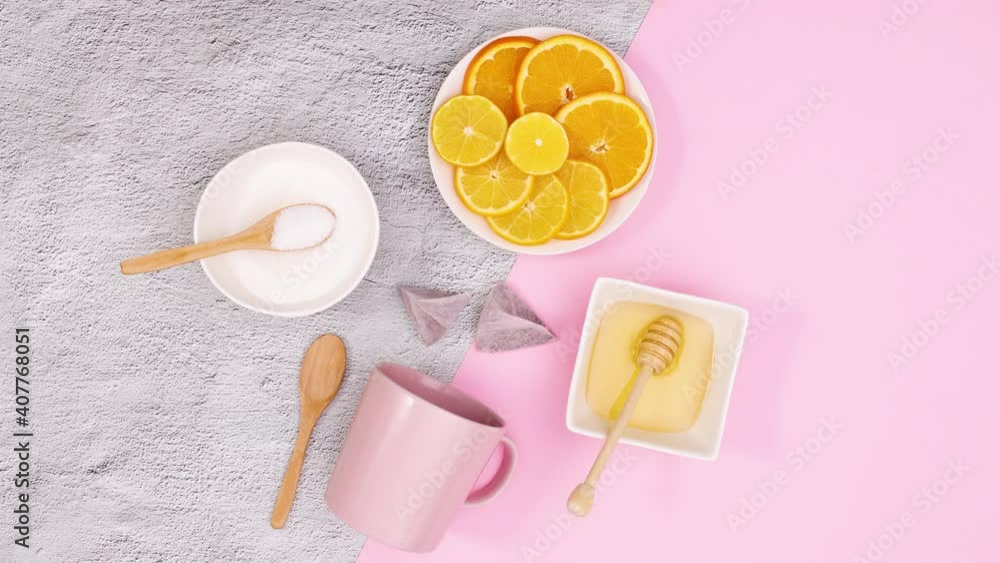 Pink tea cup, lemons, honey and tea supplies appear. Stop motion Pink tea cup, lemons, honey and tea supplies appear. Stop motion