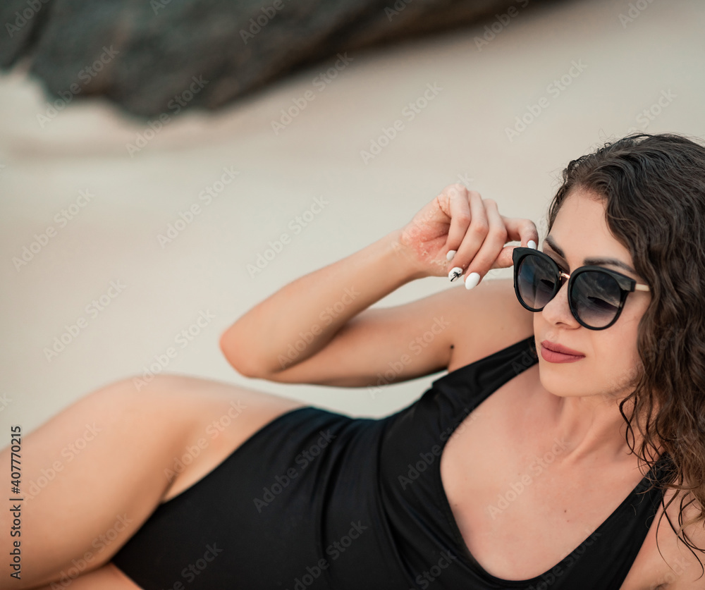 young beautiful woman in black luxury bikini posing on the palm tree. Blue ocean background. Woman in bikini at tropical beach resort. woman in hat on the beach young beautiful woman in black luxury bikini posing on the palm tree. Blue ocean background. Woman in bikini at tropical beach resort. woman in hat on the beach
