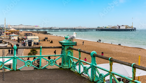 Looking over the promenade railings towards the Palace Pier in Brighton, UK on a sunny day