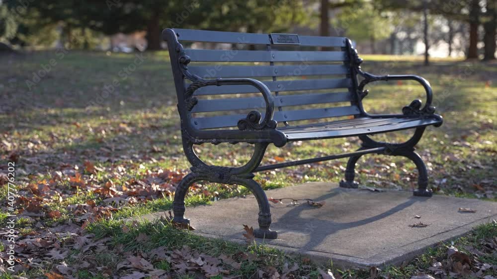 Handheld Slow Motion of Public Park Bench Under Sun in Fall Autumn Leaves and Sunny Weather and Grass Handheld Slow Motion of Public Park Bench Under Sun in Fall Autumn Leaves and Sunny Weather and Grass