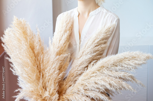 Woman in White Blouse Holding Pampas Grass. Lifestyle.Reed Plume Stem, Dried Pampas Grass, Decorative Feather Plant Arrangement for Home, Trendy Home Decor.