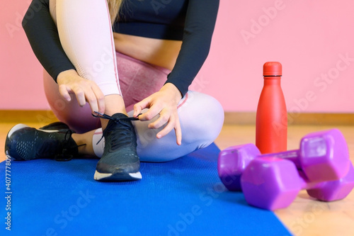 Close Up Of Woman Tying Laces Of Training Shoes Before Exercise. High quality photo