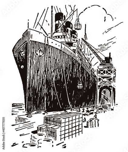 Huge cargo ship in three-quarter front view, lying alongside a quay of a seaport is being unloaded