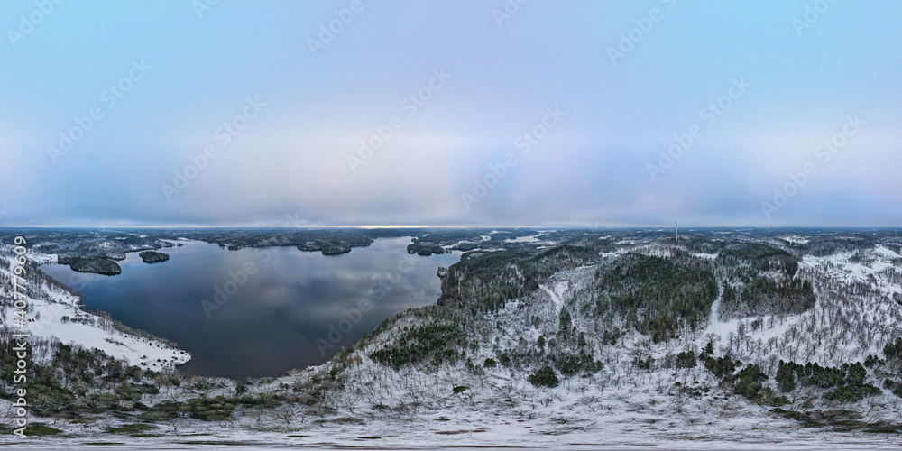 360 photo of a Winter landscape on a hill (Liagarde) with a breathtaking view in Sweden, Scandinavia..Snow, trees, lake and a wind mill in the background. Photo taken by drone.