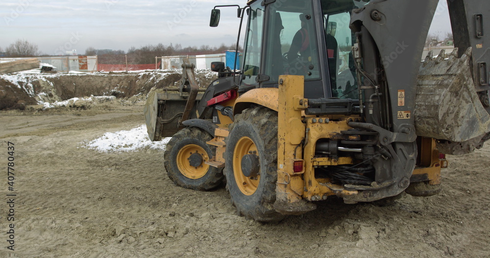 Construction Machinery At Work On Building A House. Different Types Of Tractors And Excavators Prepare The Soil For Plant Construction In The Industrial Zone. Bulldozer Rides on Sandy Road Construction Machinery At Work On Building A House. Different Types Of Tractors And Excavators Prepare The Soil For Plant Construction In The Industrial Zone. Bulldozer Rides on Sandy Road