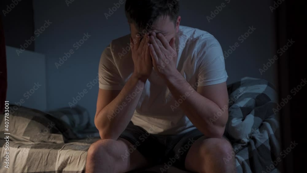 Troubled man with pills for insomnia in bedroom. Male with terrible headache take pill at night. Sleeping disorder medicine. Sick guy drinking pills in bed at night. Pain while trying to fall asleep