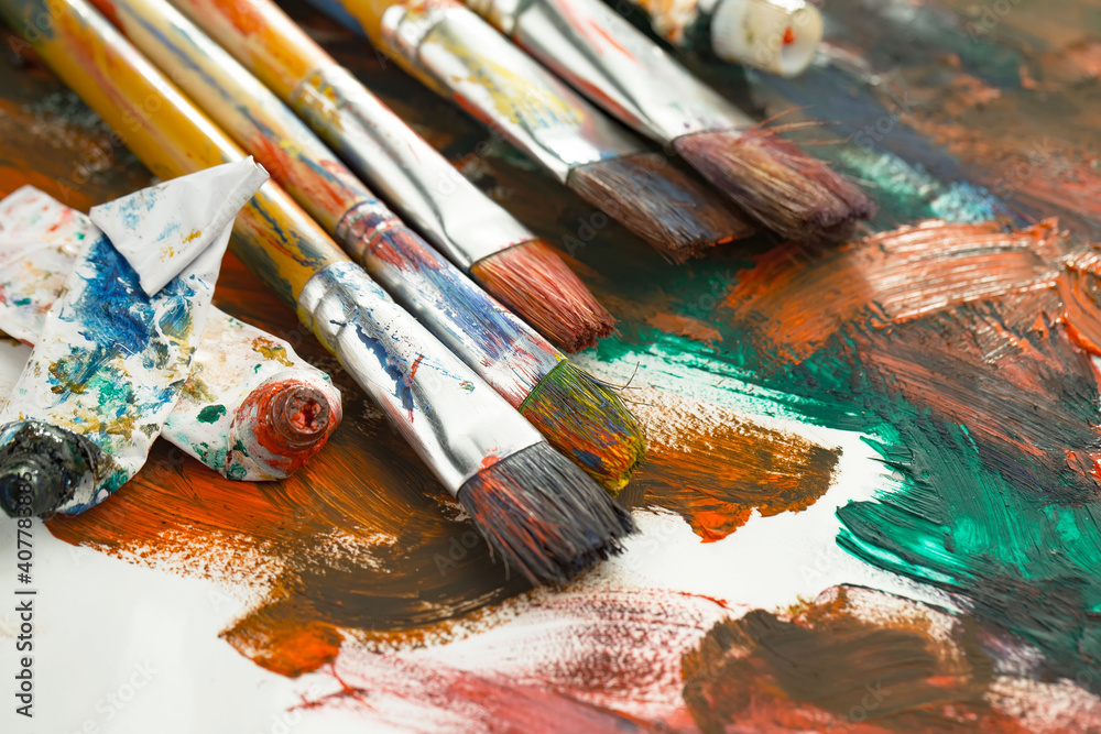 Fototapeta premium Brushes and paints for painting on an old background.