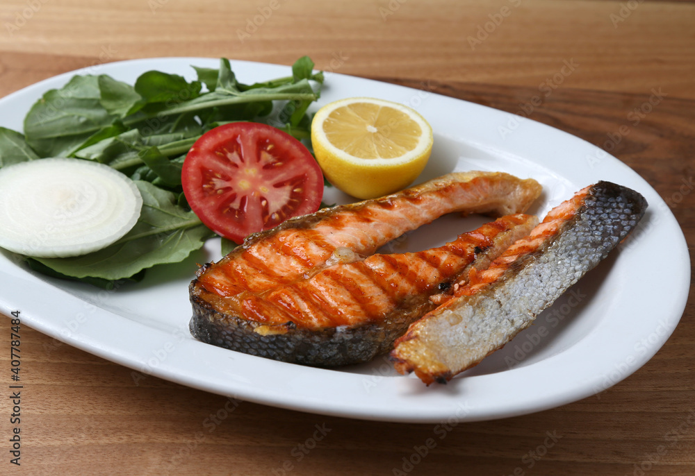 Grilled salmon with rocket and lemon slice Grilled salmon with rocket and lemon slice