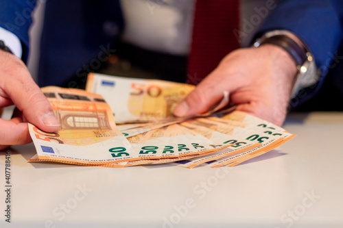 Business man showing in hand fifty euro banknote. Financial and money saving concept