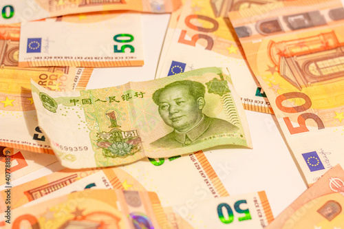 Fifty euro money banknotes background texture and Mao Zedong portrait on 1 Chinese paper currency Yuan renminbi in close up photo