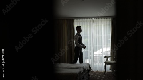 Wallpaper Mural Buttoning shirt, walking near window. Stylish man in jacket fastens buttons and straightens his white shirt preparing to go out. Get ready before date or meeting fashion style weight fit. Slow motion Torontodigital.ca