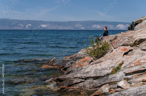 Woman on a rocky shore near the water of Lake Baikal © Oksy001