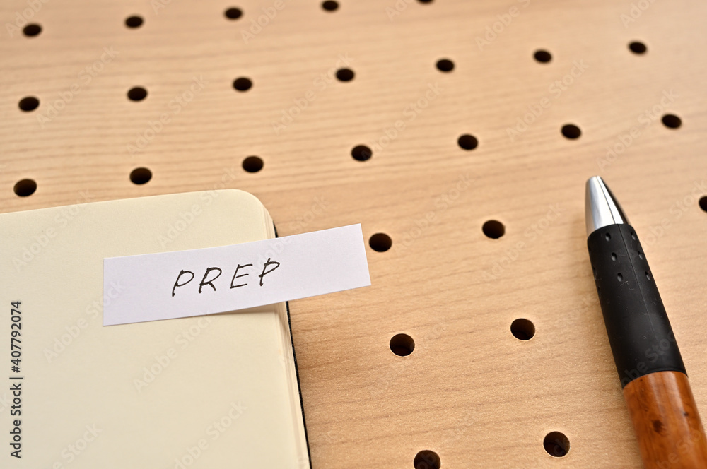 a-sticky-note-with-prep-written-on-the-edge-of-an-open-notebook-on-the