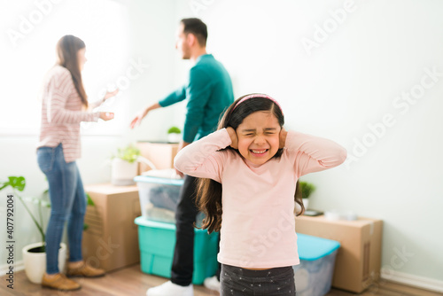 Scared daughter with eyes closed during a fight of mom and dad