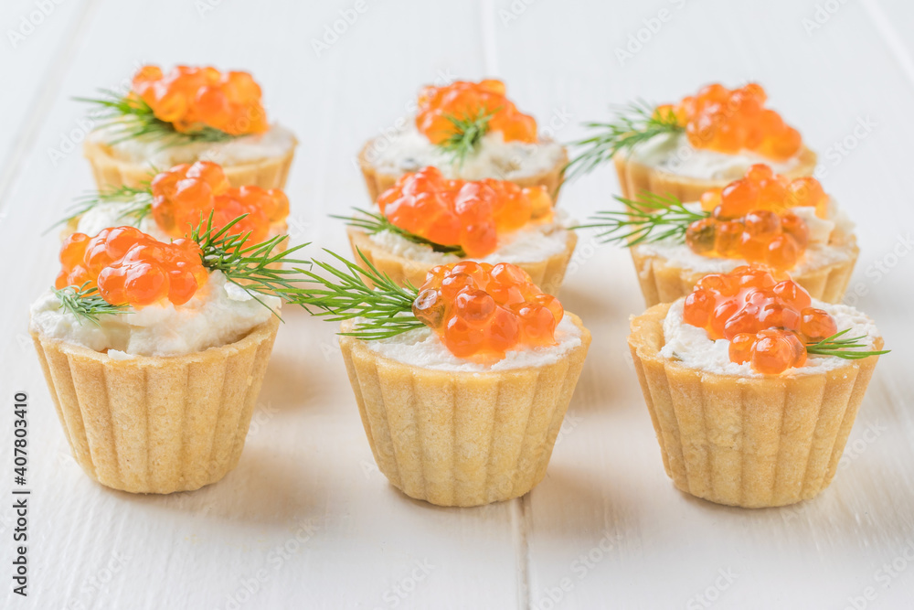 Tartlets with caviar and cream cheese on a white wooden table. Tartlets with caviar and cream cheese on a white wooden table.