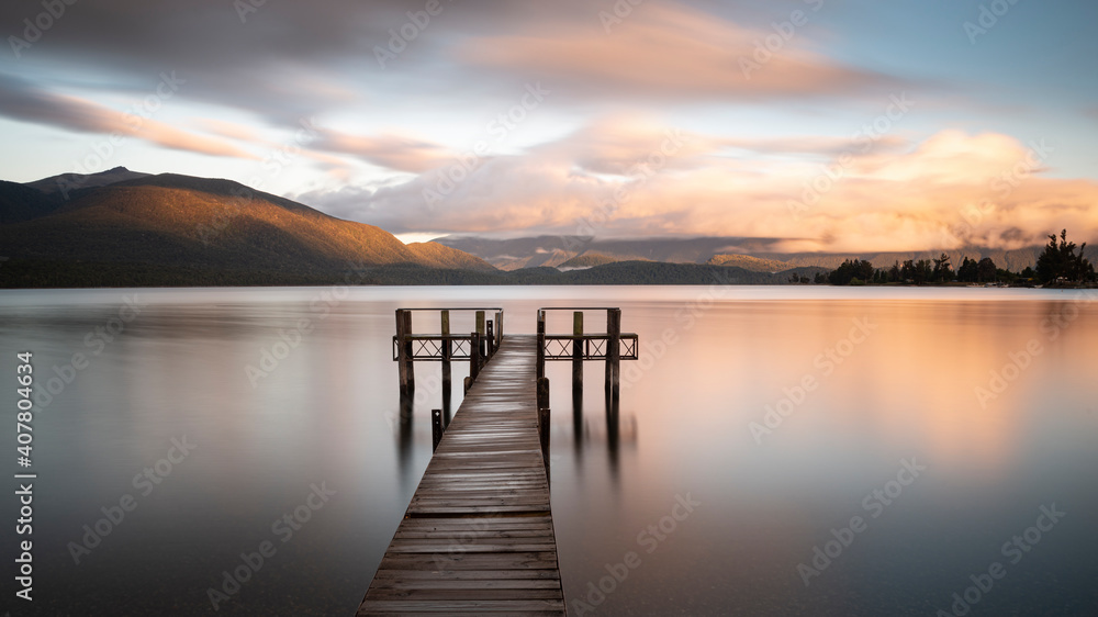 Long exposure image of lake Te Anau jetty at sunrise with a spectacular backdrop of Mt Luxmore and the Murchison mountains
