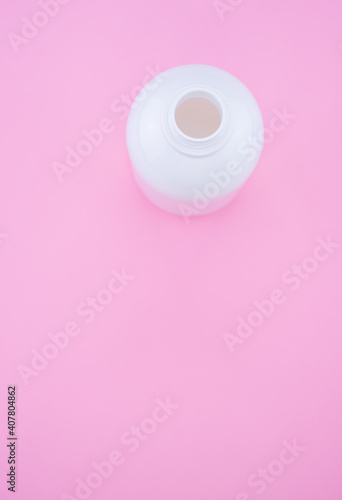 Vertical shot of an empty bottle isolated on pink background photo