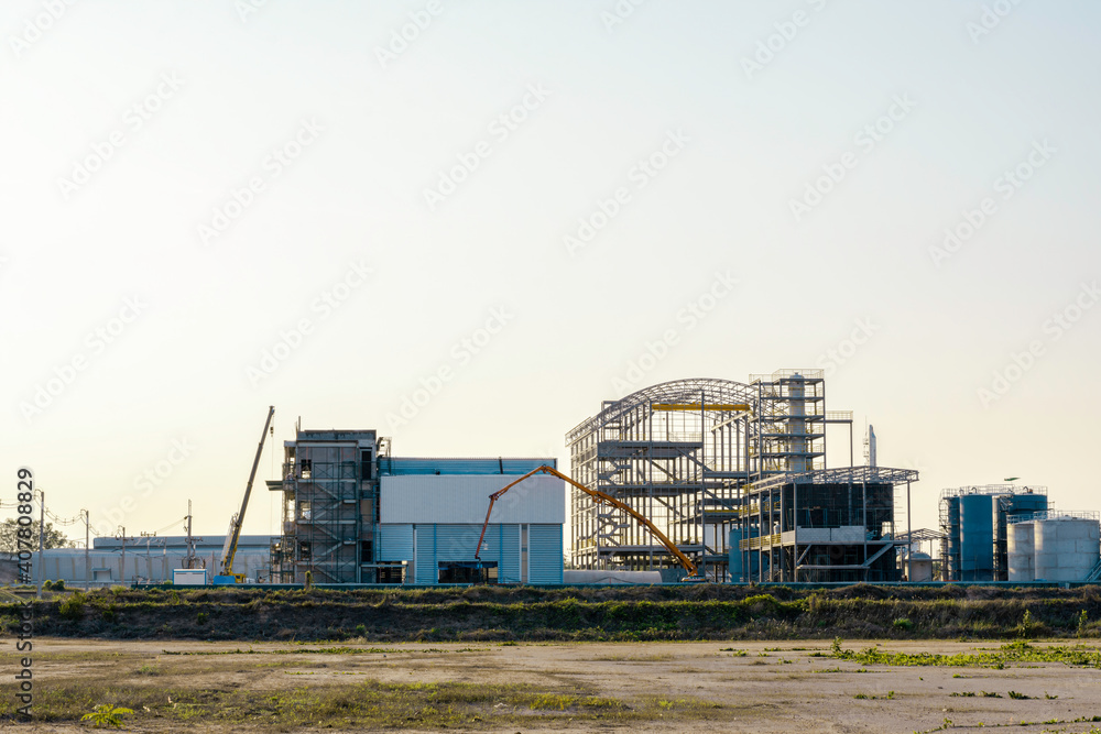 Under Construction site of modern factory building, Unfinished factory building with sunset sky Under Construction site of modern factory building, Unfinished factory building with sunset sky