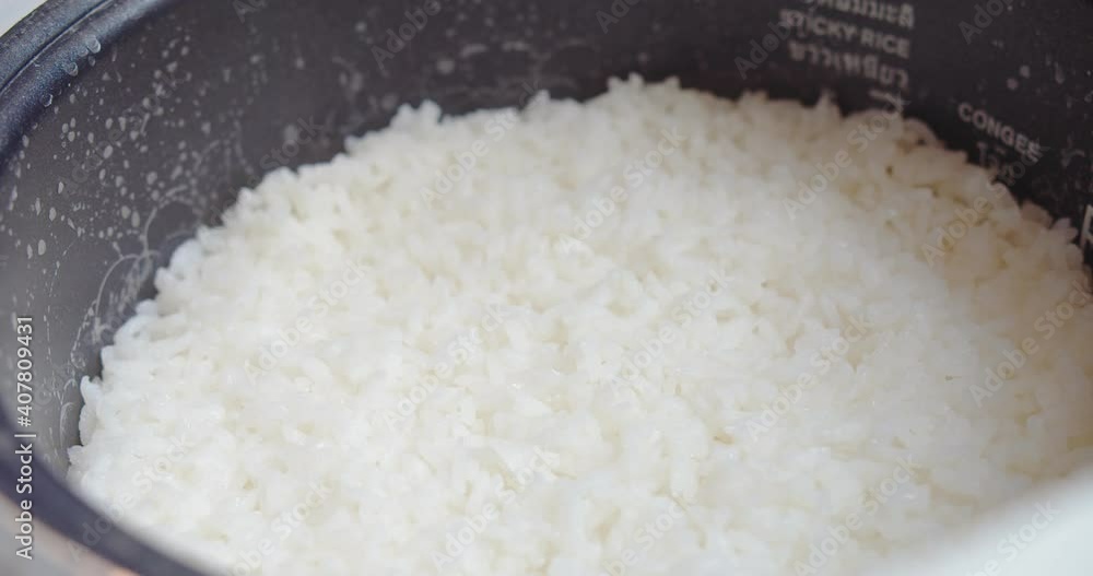 Close up Cooked steamed hot white jasmine rice in electric rice cooker, cultural staple food in Asia, rich nutrient good health Close up Cooked steamed hot white jasmine rice in electric rice cooker, cultural staple food in Asia, rich nutrient good health