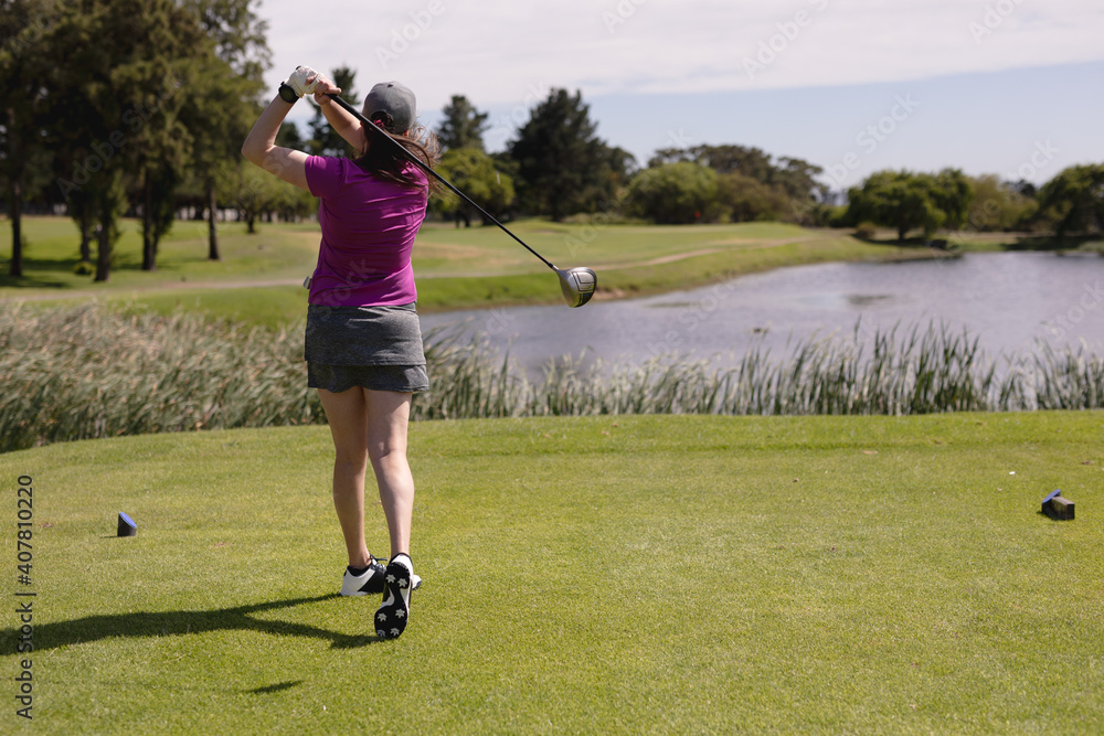 Caucasian woman playing golf swinging club and taking a shot Caucasian woman playing golf swinging club and taking a shot