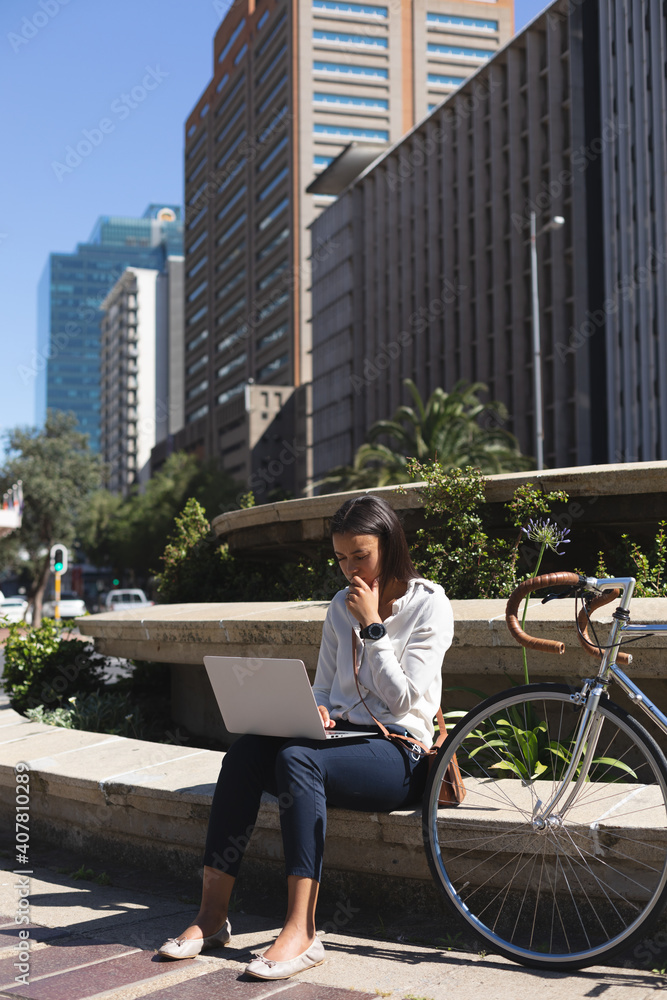 African american woman using laptop while sitting at corporate park