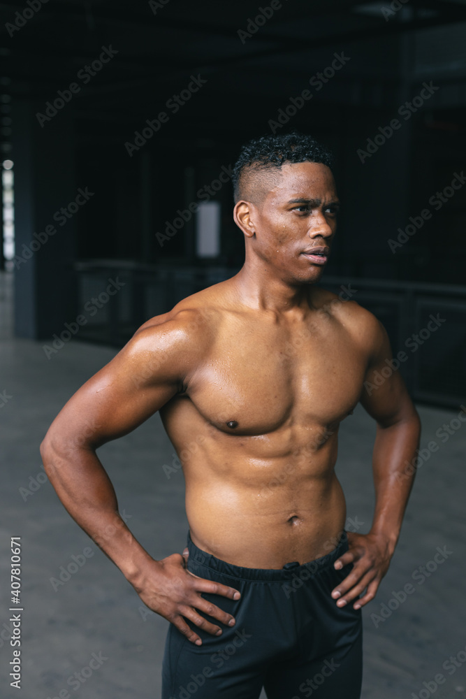 African american man standing and flexing his muscles in empty urban building African american man standing and flexing his muscles in empty urban building