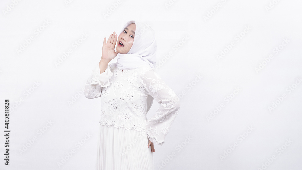 Asian muslim woman wearing prayer beads shouting and yelling in white background Asian muslim woman wearing prayer beads shouting and yelling in white background