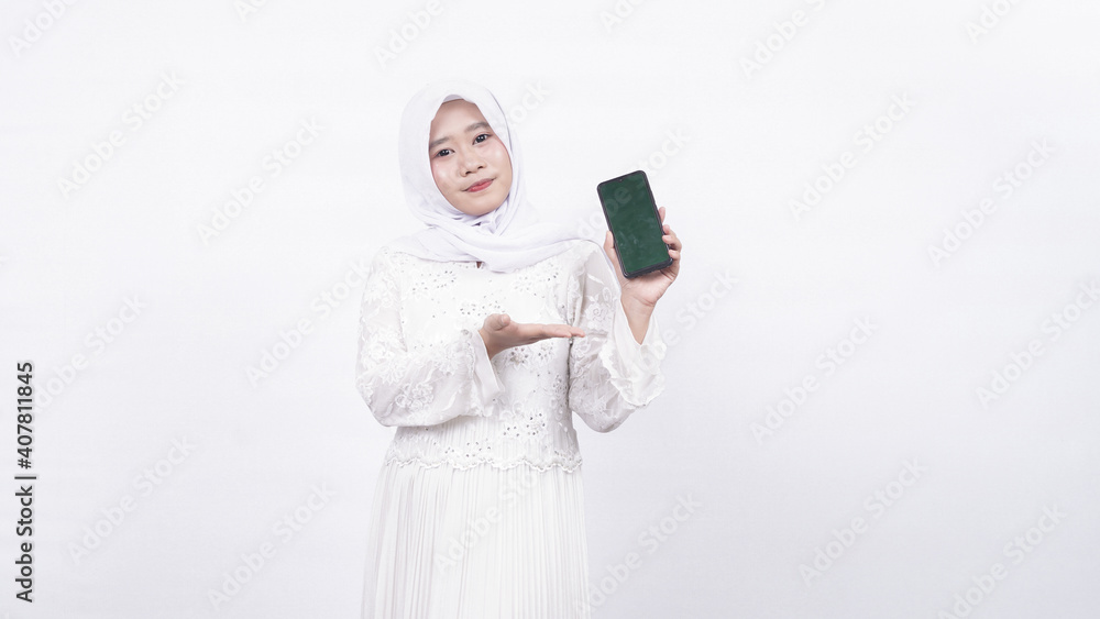 Asian muslim woman wearing prayer beads holding blank screen phone in white background Asian muslim woman wearing prayer beads holding blank screen phone in white background