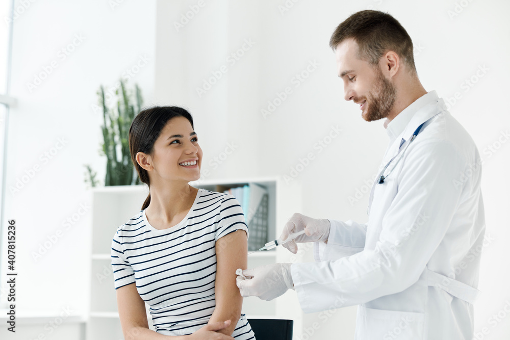 male doctor in a white coat injecting a woman's hand in a health hospital vaccination male doctor in a white coat injecting a woman's hand in a health hospital vaccination