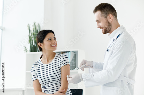 male doctor in a white coat injecting a woman s hand in a health hospital vaccination