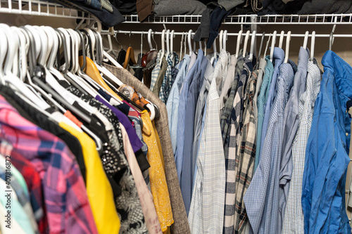 Male and female clothes arranged and hanging in a walk in closet