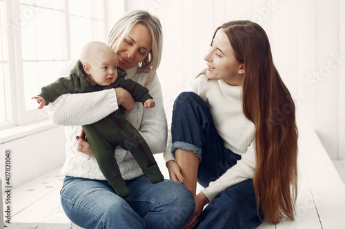 Family at home. Grandmother with daughter and granddaughter. Women in a white sweaters.