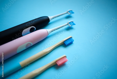 electric and bamboo toothbrushes on a blue background. zero waste