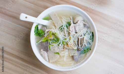 A bowl of pork noodle soup is on the table