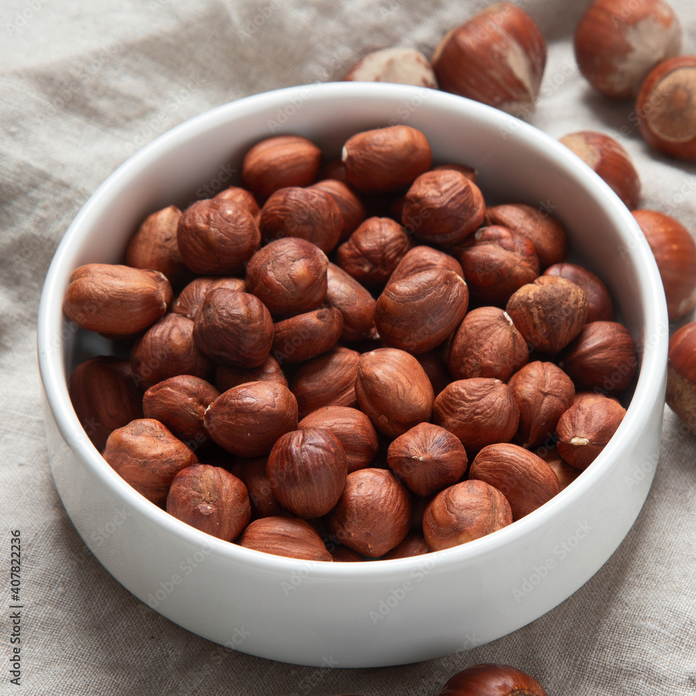 Fototapeta premium Organic hazelnut in bowl on dark grey