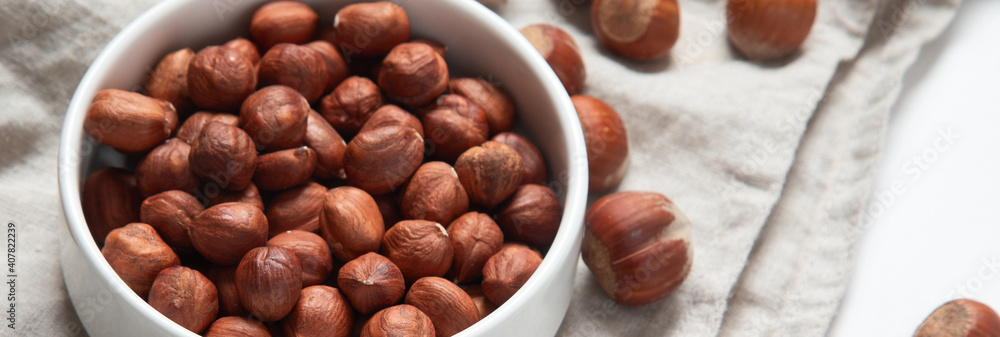 Organic hazelnut in bowl on dark grey Organic hazelnut in bowl on dark grey