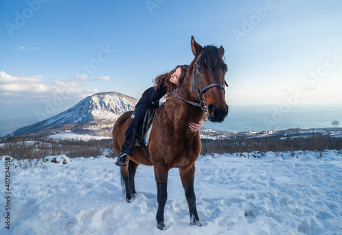 young woman with horse in winter 