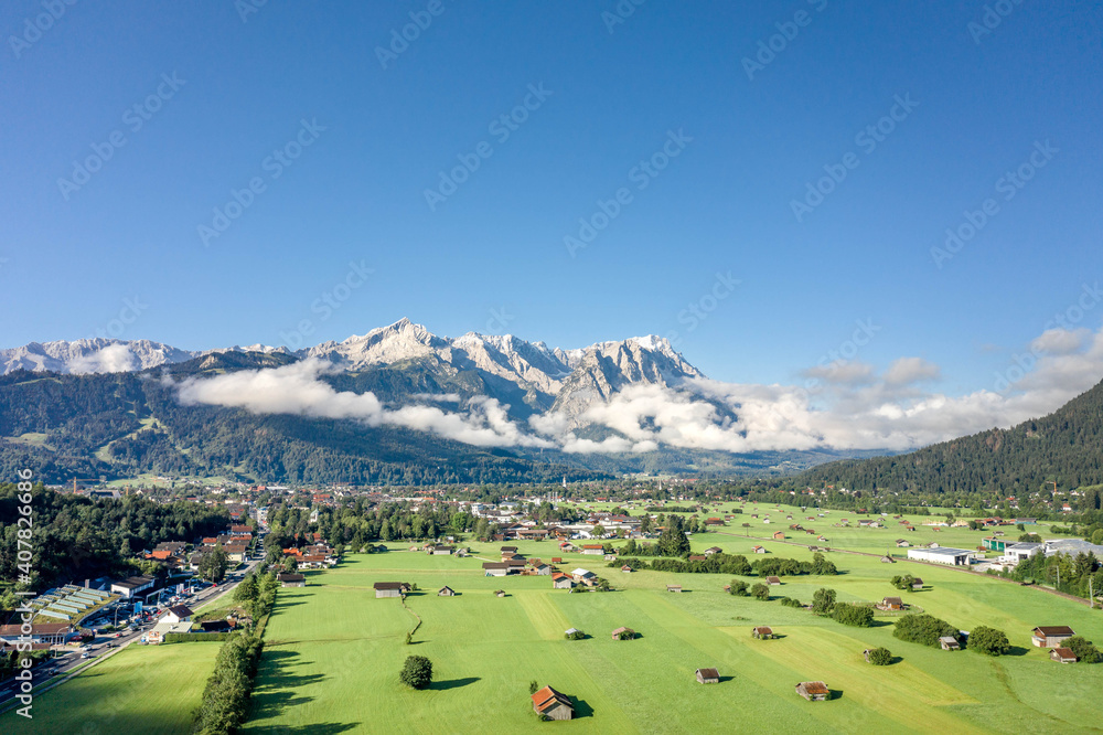 Aerial drone shot of village Garmisch Partenkirchen with view of Zugspitze in fog