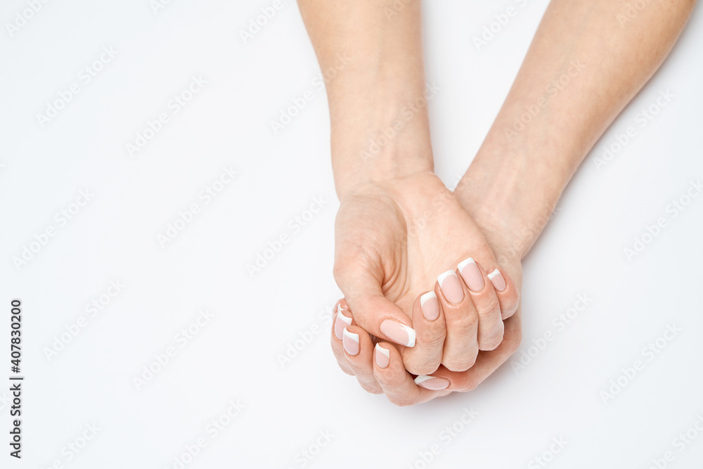 Beautiful Female Hands with French manicure over light grey background Beautiful Female Hands with French manicure over light grey background