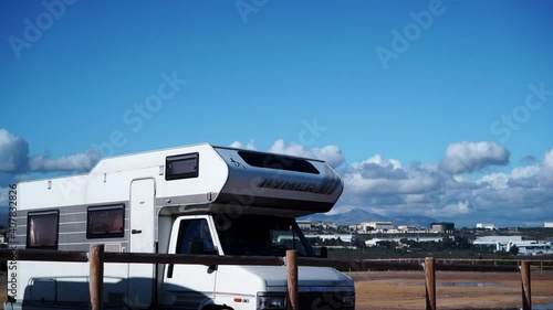 Alicante, Spain - December 5, 2019: Old Hymer camper rv on coast near seaside spanish Alacant city on the Costa Blanca. Caravan vacation. Time lapse photo