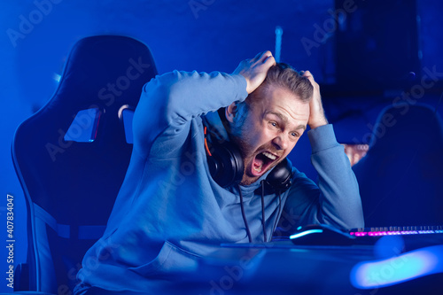 фотографія Streamer Angry computer gamer man yells after being defeated in online video gam