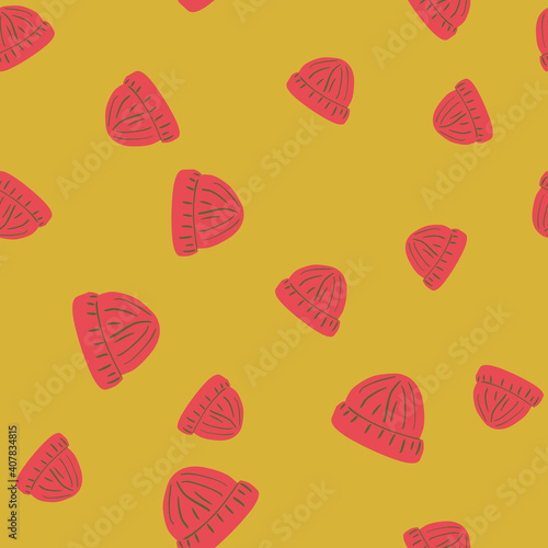 Random pink colored beanie hat seamless doodle pattern. Yellow background. Warm winter backdrop.