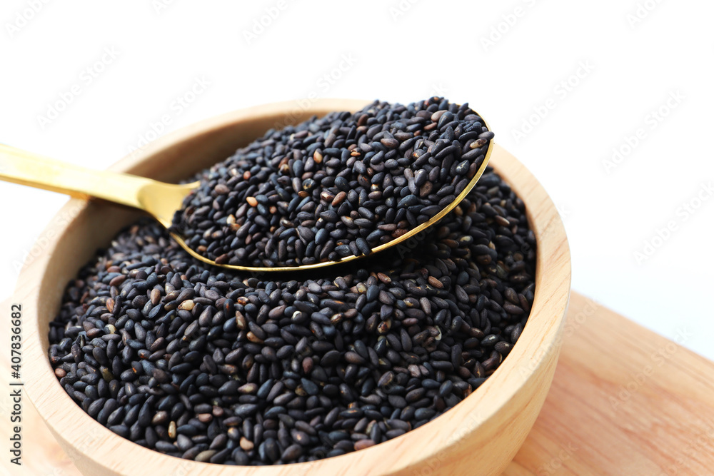 Black sesame seeds in wooden bowl. Black sesame seeds in wooden bowl.