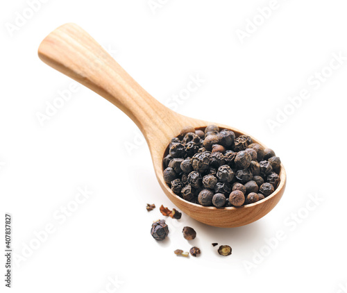 Black pepper in a wooden spoon isolated on white background