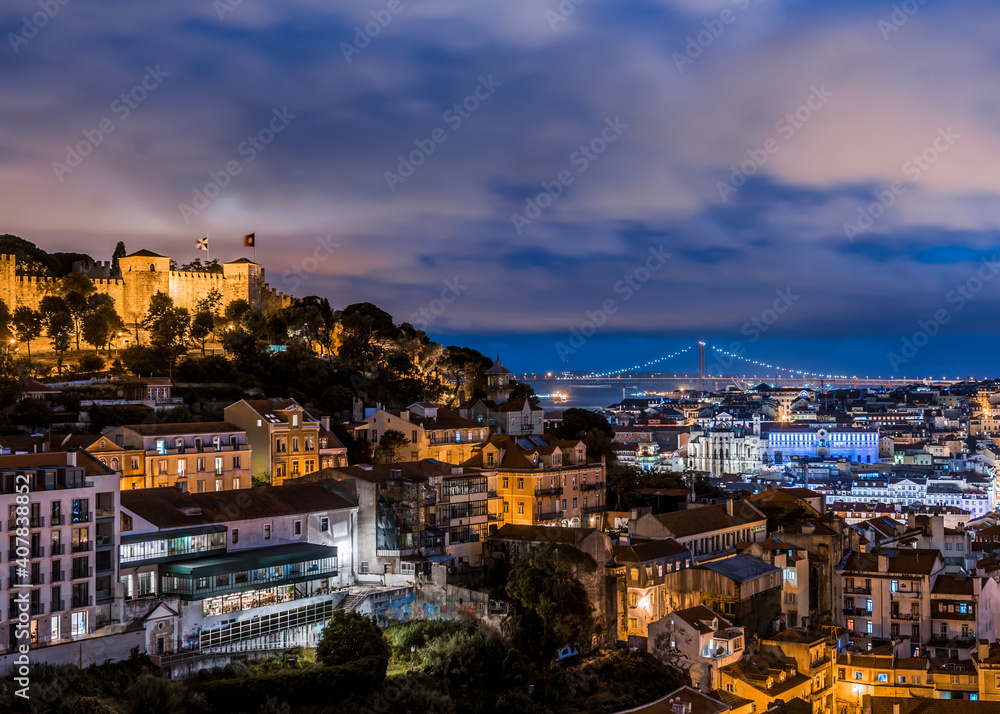 View of St. George's castle and the 25th April Bridge in Lisbon at night