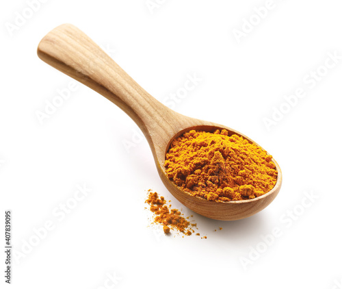 Turmeric powder spices in a wooden spoon isolated on white background