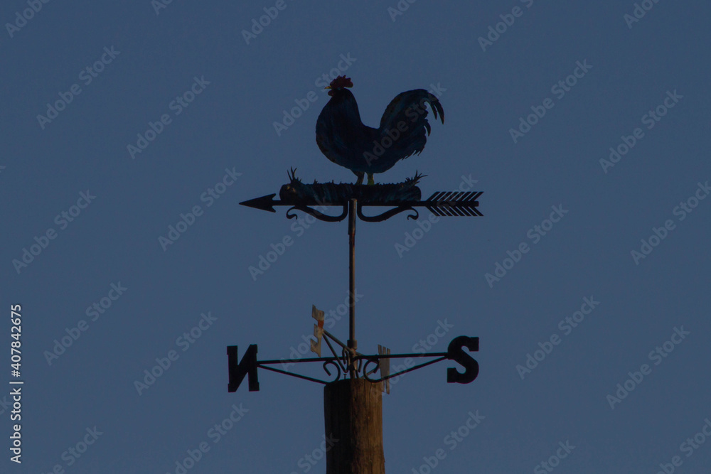 Weather Vane Rooster,Wind Vane or weathercock with dusk background,local at Bracciano port,Italy. Weather Vane Rooster,Wind Vane or weathercock with dusk background,local at Bracciano port,Italy.